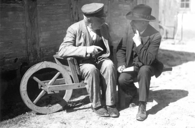 Ældre mænd i samtale siddende på gammel trillebør