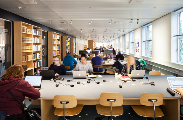 Studerende med laptops i biblioteksrum